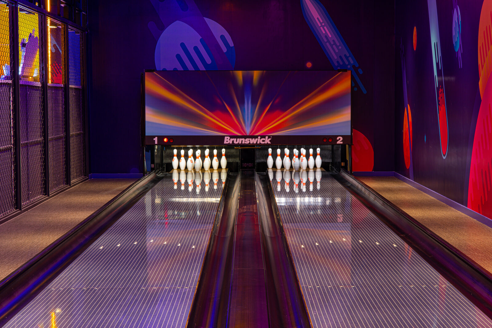 Two full size bowling lanes with synthetic lane beds, pin decks and overhead masking unit at a Vietnamese entertainment centre
